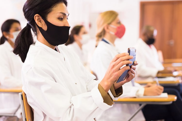 A medical device sales rep presenting a medical device to a group of healthcare professionals